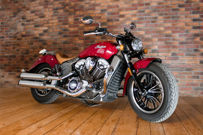 a red motorcycle is parked against a brick wall