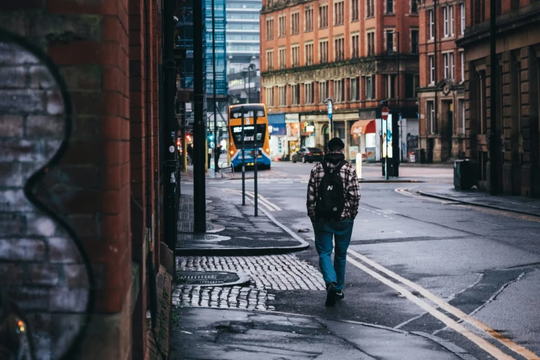 a man walking down a street in front of a building