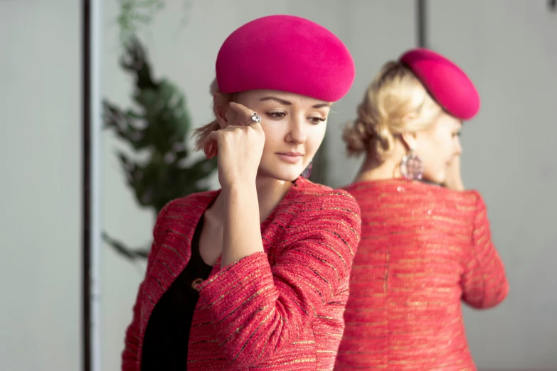 two women with big hair wearing bright hats