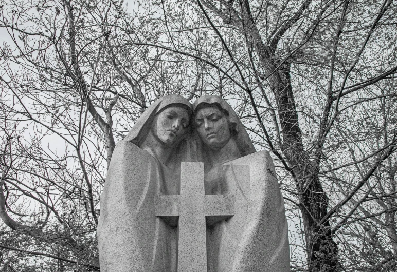 a couple of statues sitting in front of a tree