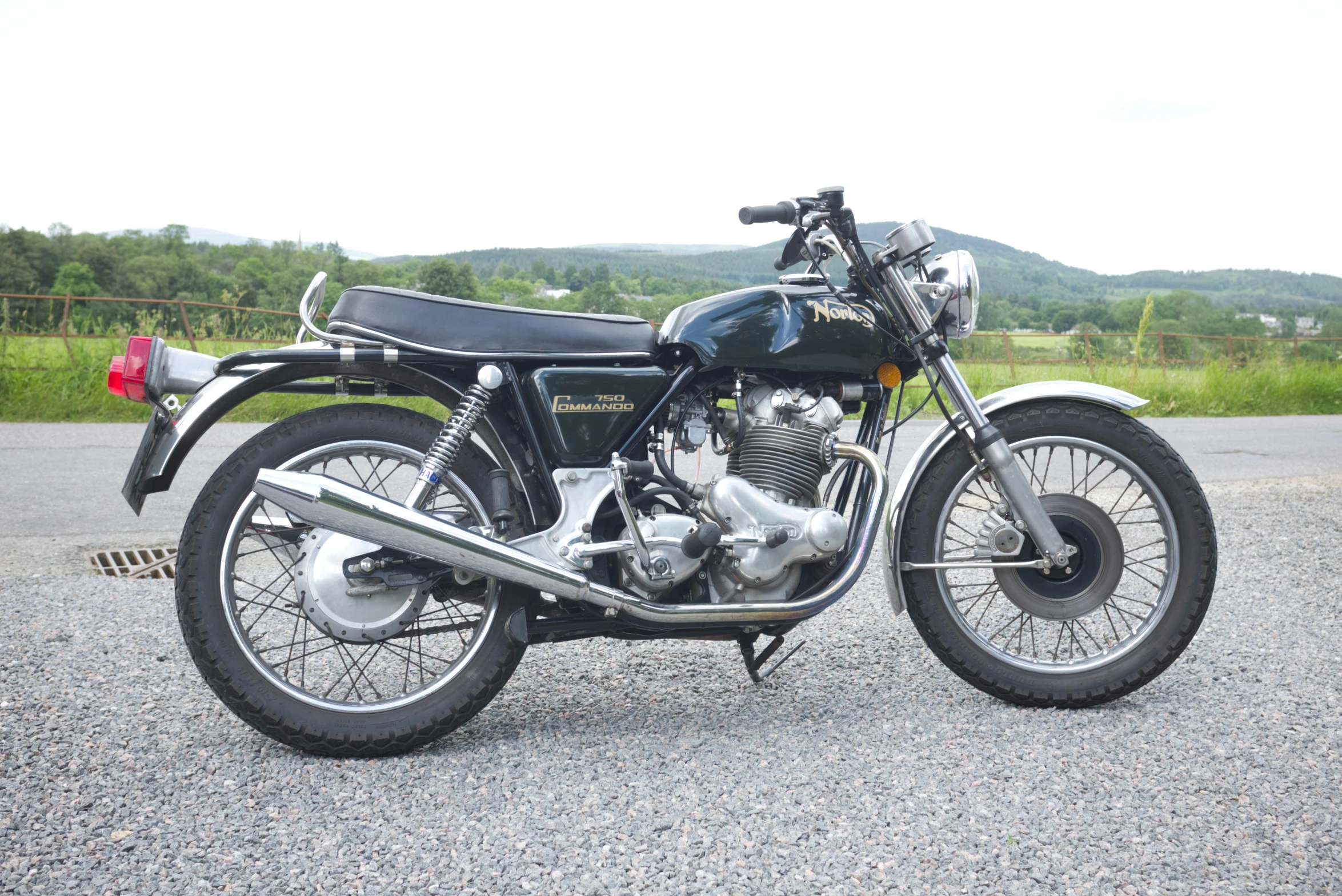 the black motorcycle is parked near a scenic view