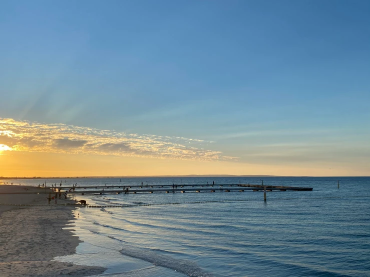 the sun is shining on the water of the beach