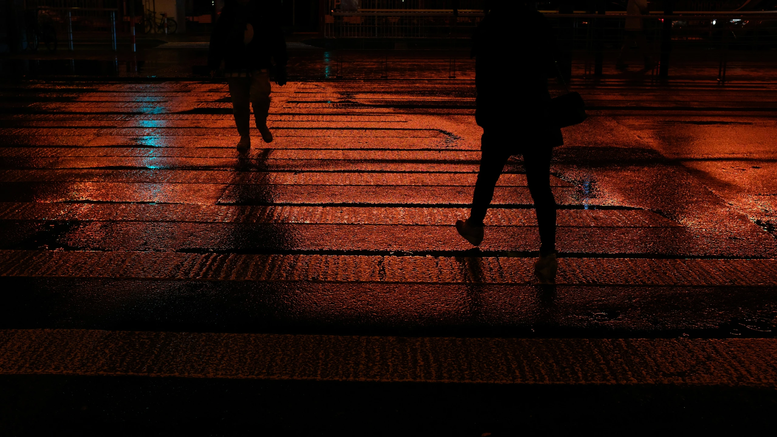 people are walking down the street in the rain