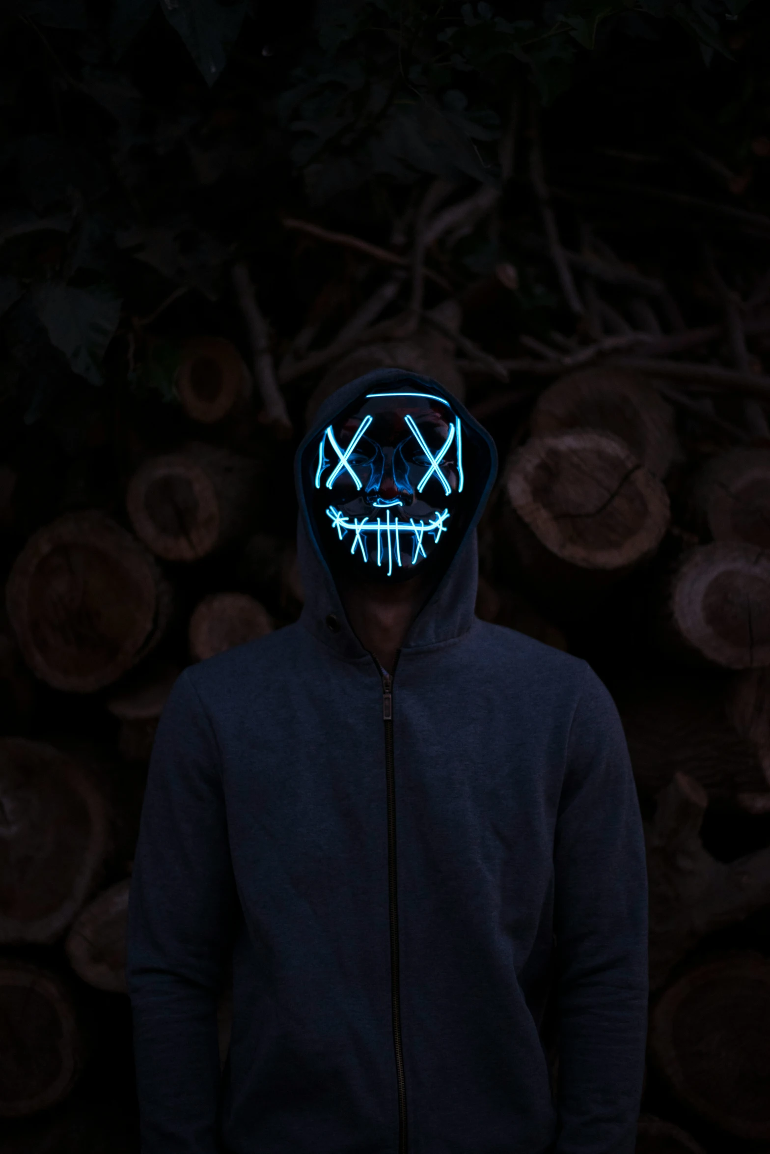 a person with a blue neon skull mask on