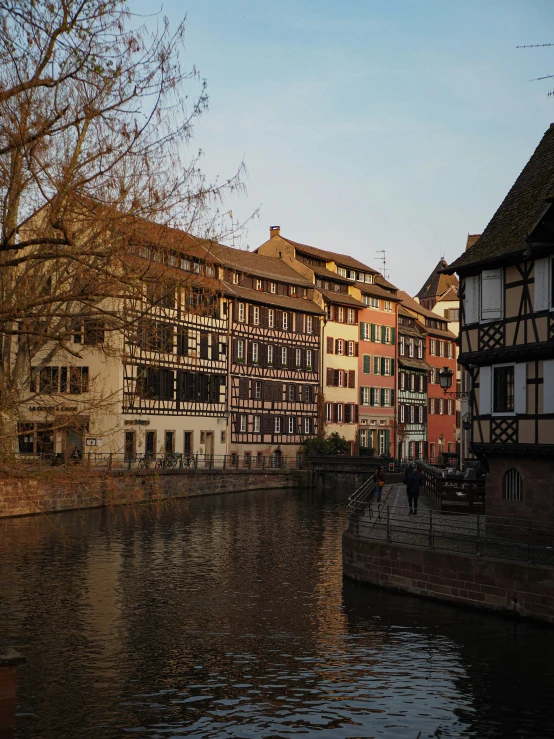 a river runs through an old city on a sunny day