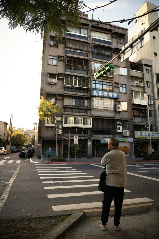 two people standing on the corner near a very tall building