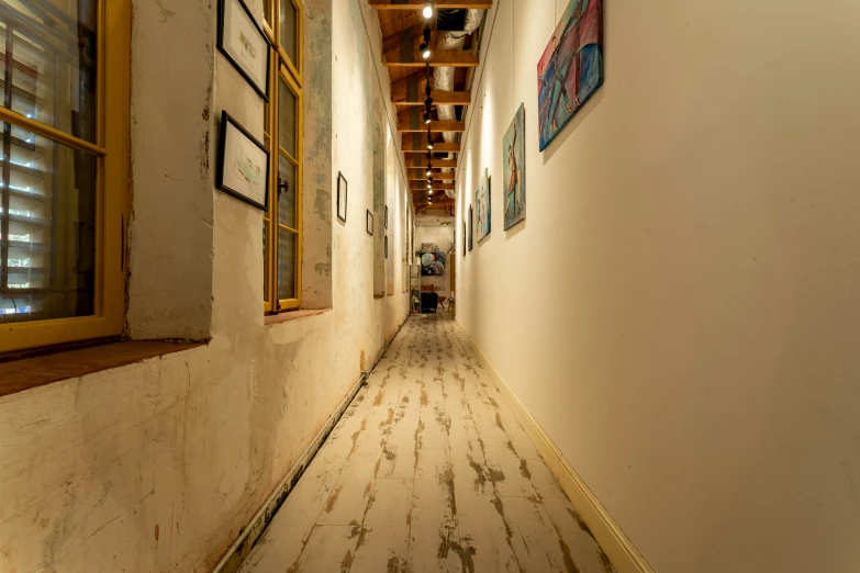 narrow hallway illuminated by wood planks in old building