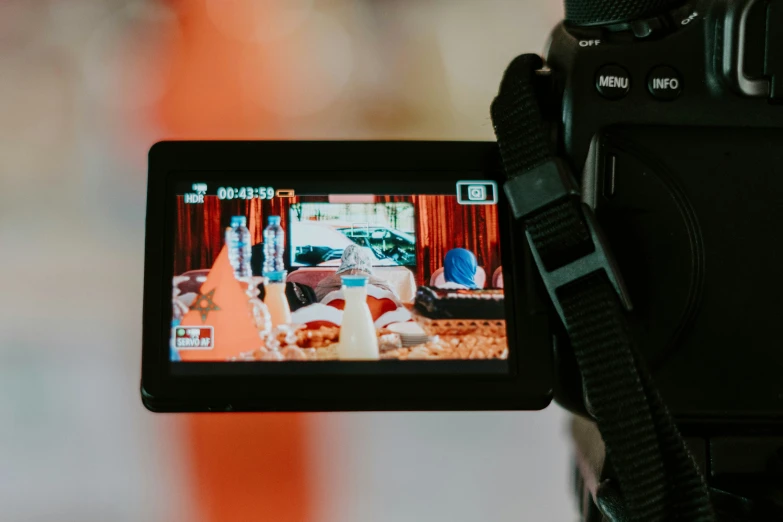 a man holding up a camera that is displaying a video