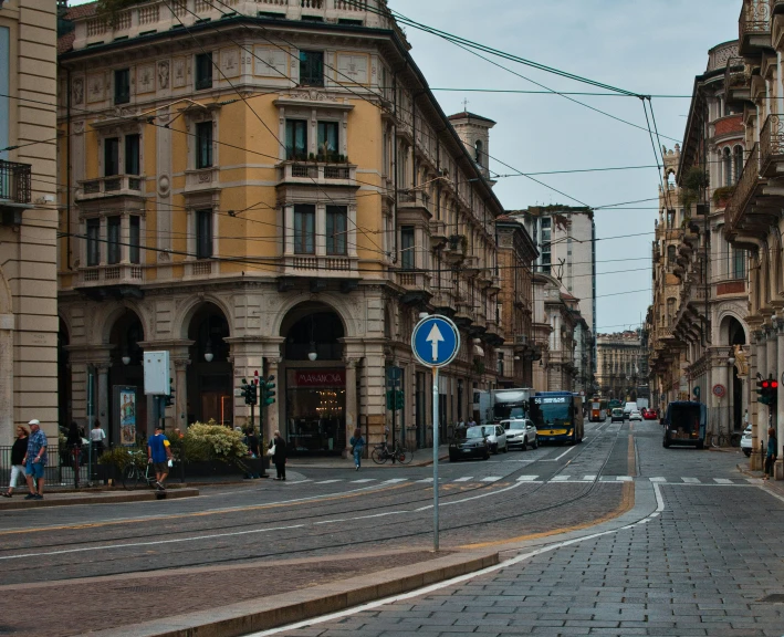 an old city street with cars driving down it