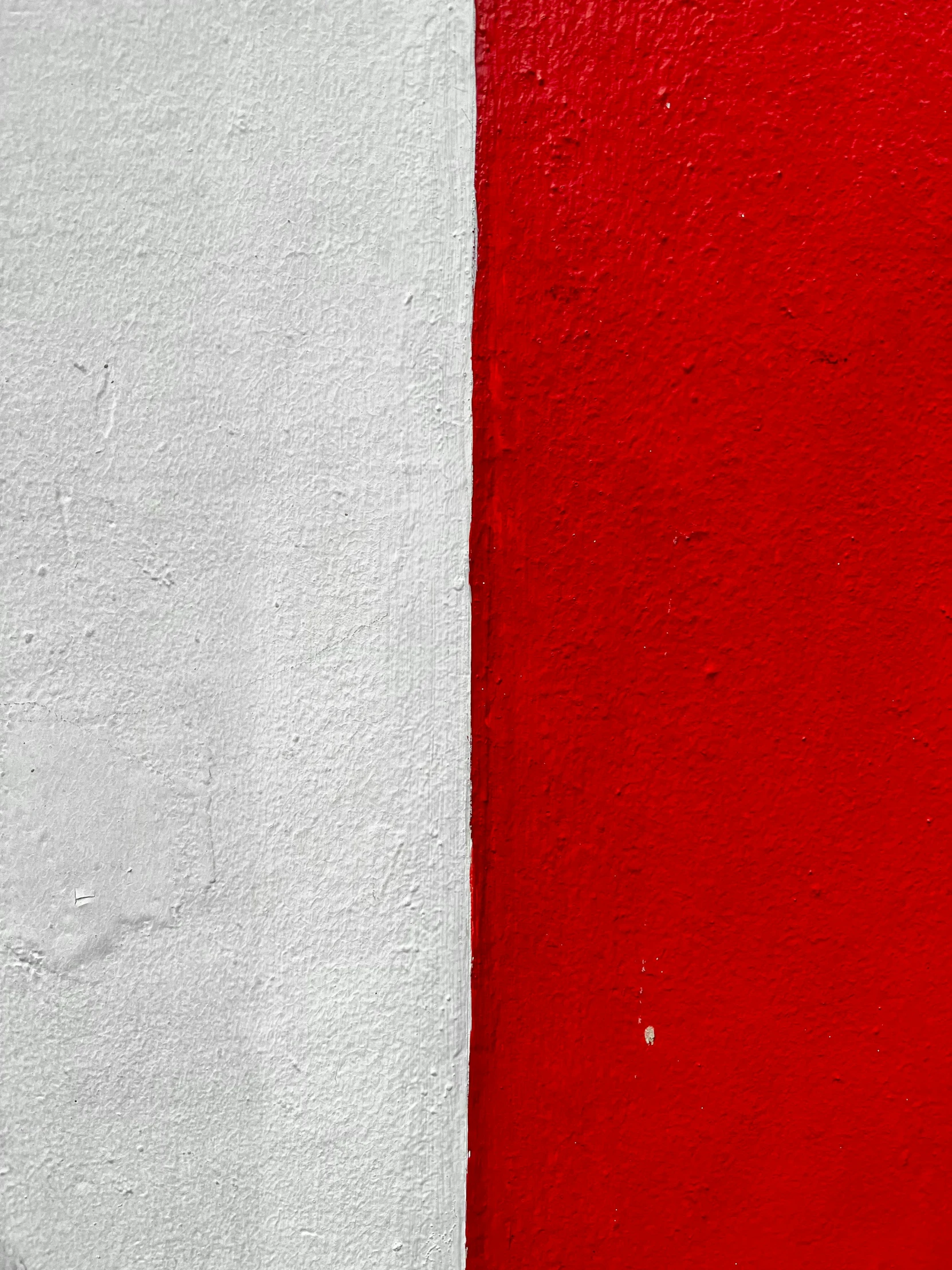 a red and white wall is painted two colors