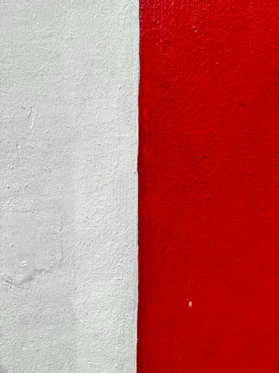 a red and white wall is painted two colors