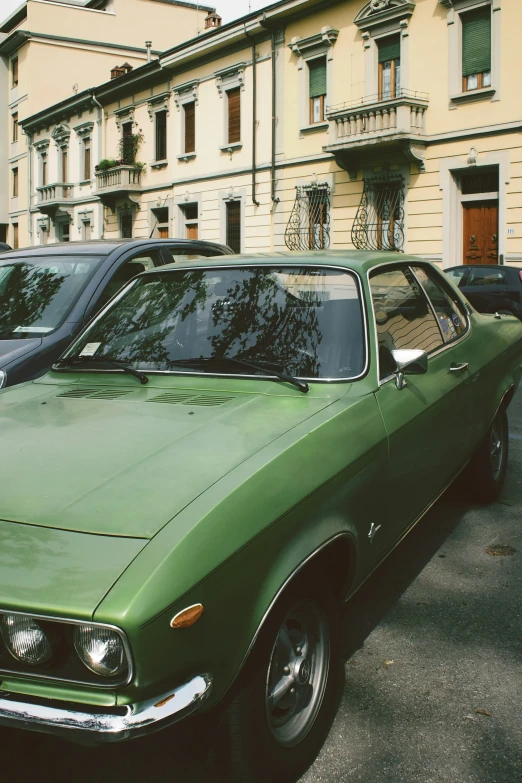 a green car parked in a parking space next to other cars