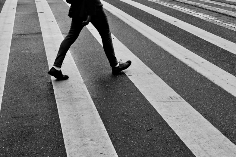 a person crossing a street on their cell phone