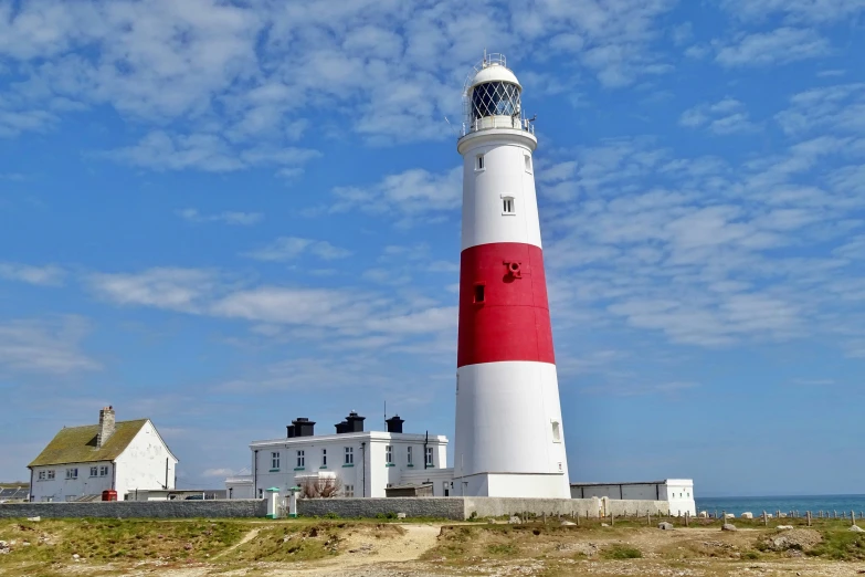 a white and red light house standing on top of grass