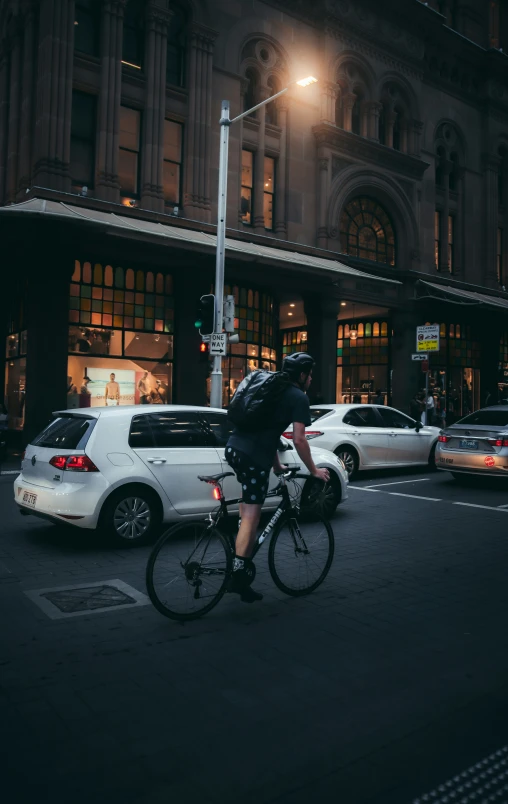 a man is on his bike at night with traffic going by