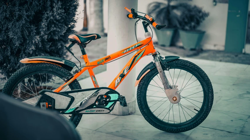 an orange bike parked next to a white column