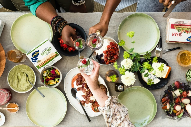 a group of people sitting around a table together with bowls and plates