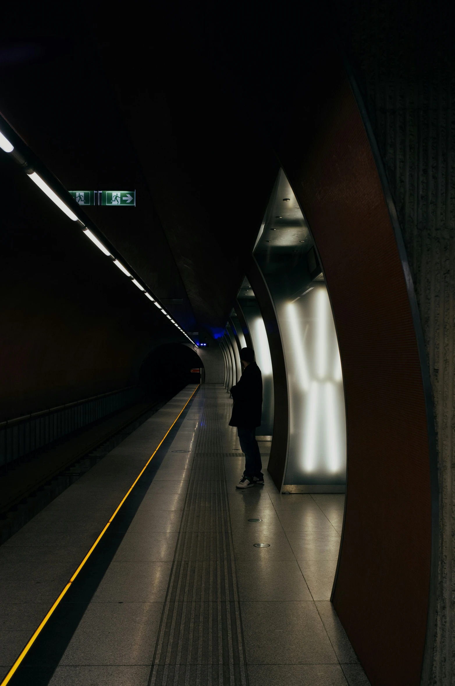 the people are walking down the walkway in the tunnel