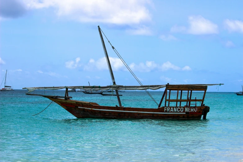 an old boat in the clear water on the beach