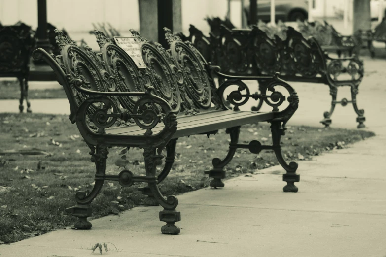 three park benches on sidewalk near a building