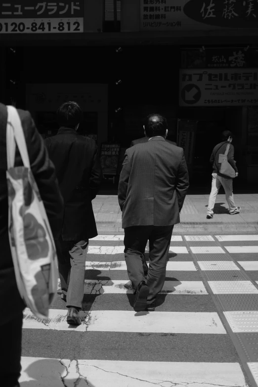 the back of two people walking down a sidewalk