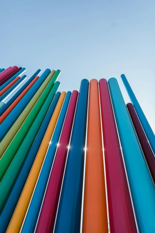 the rainbow - colored pipes are pointing upwards towards the sky