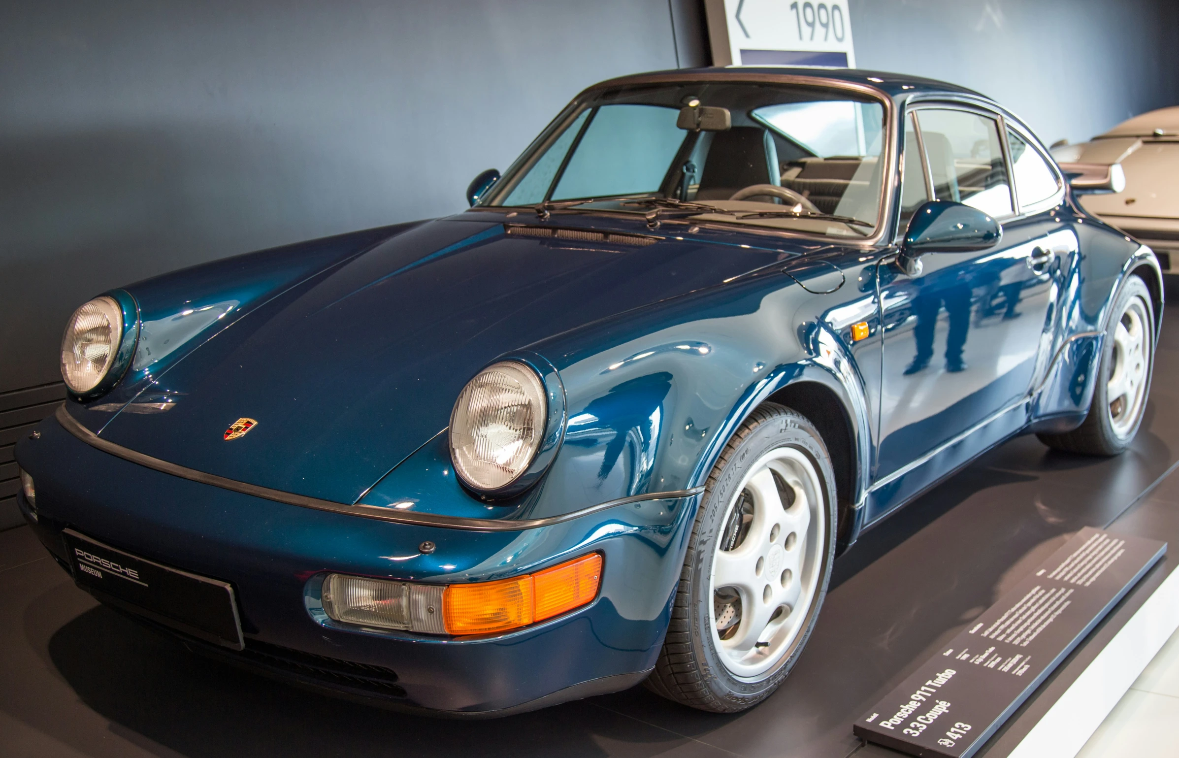 a blue porsche that is on display in a museum