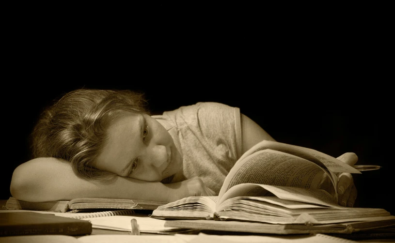 a woman laying down reading on her bed