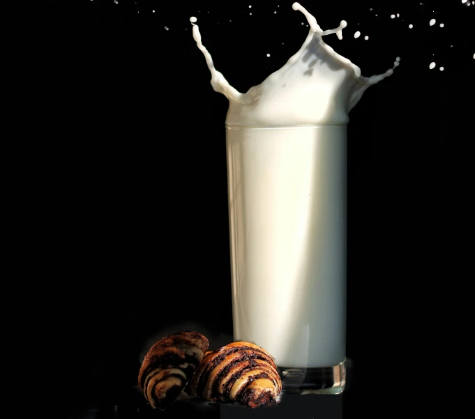 a milk shaker with milk and cinnamons in front of it