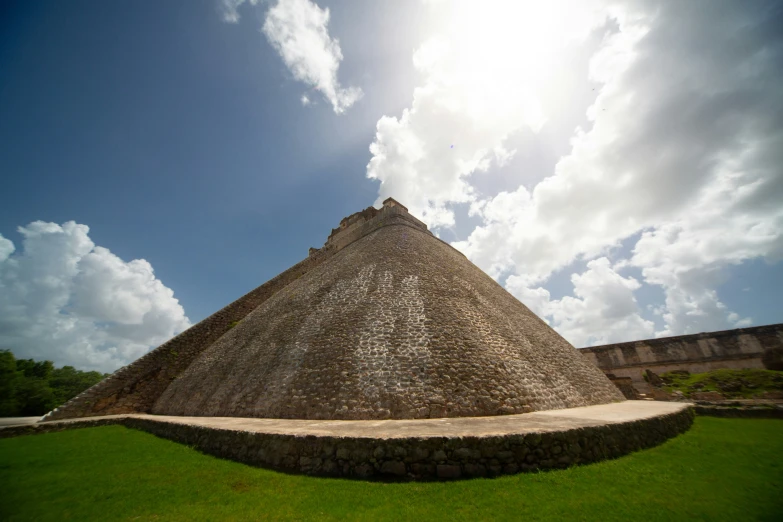 a giant, triangular structure stands next to a large wall of grass