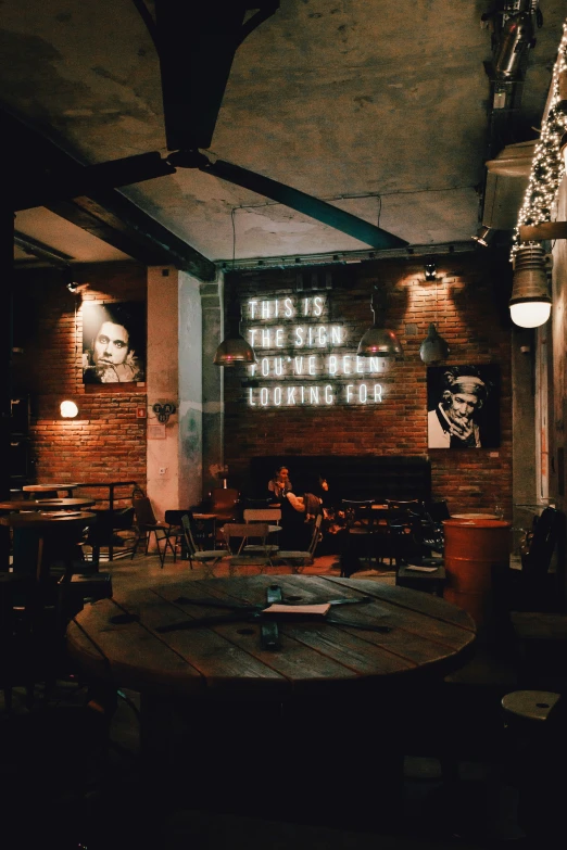 a table and chairs inside a room with brick walls