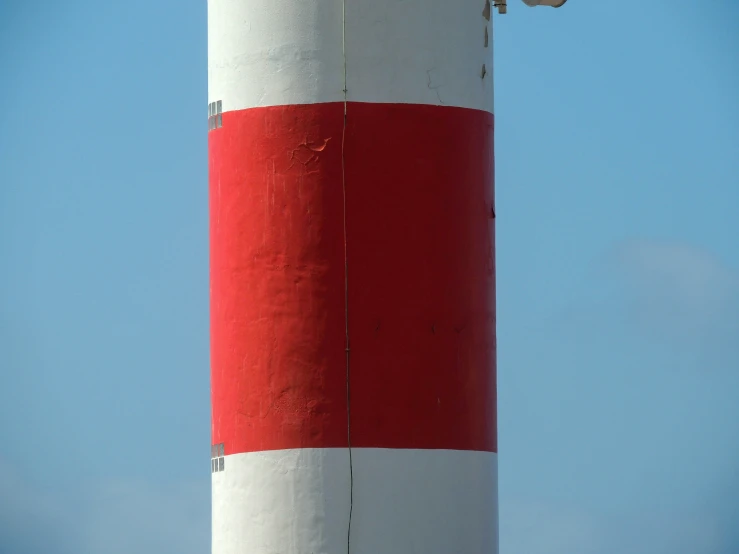 there is a red and white lighthouse that is standing on a pier