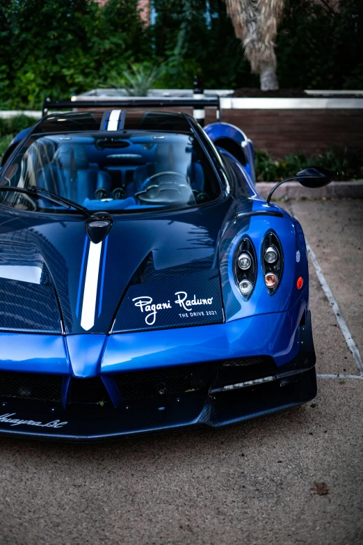 a blue sports car sits in a parking lot