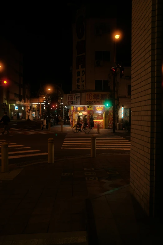 people waiting for cross walk at a crosswalk at night