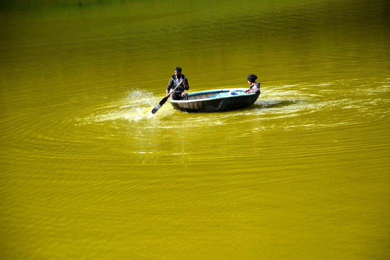 two people in a row boat are rowing through the water