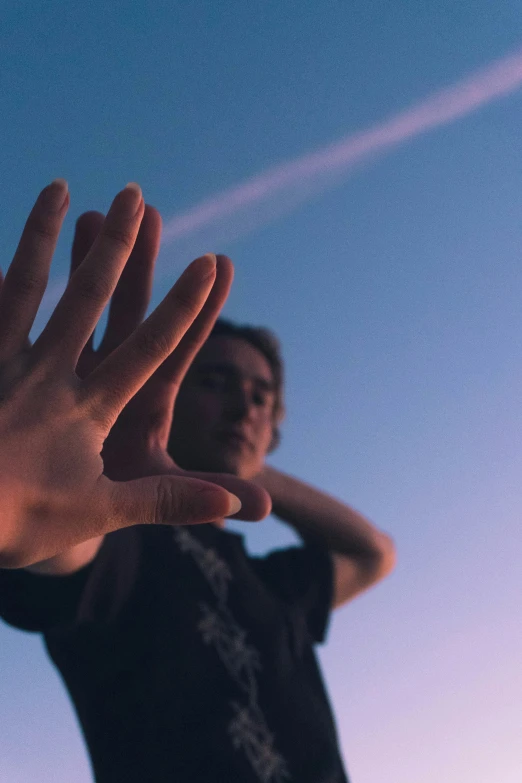 a man who is standing with his hand up