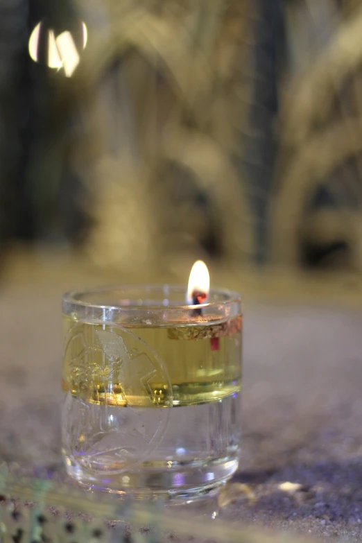 a tealight candle sitting on top of a glass cup