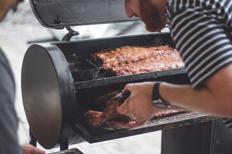 the man in striped shirt is making barbecue