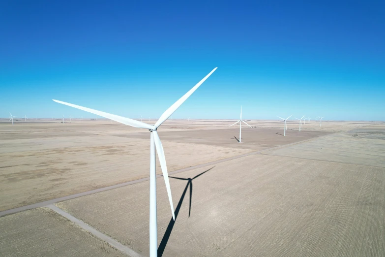 a wind farm is pictured in a wide open field