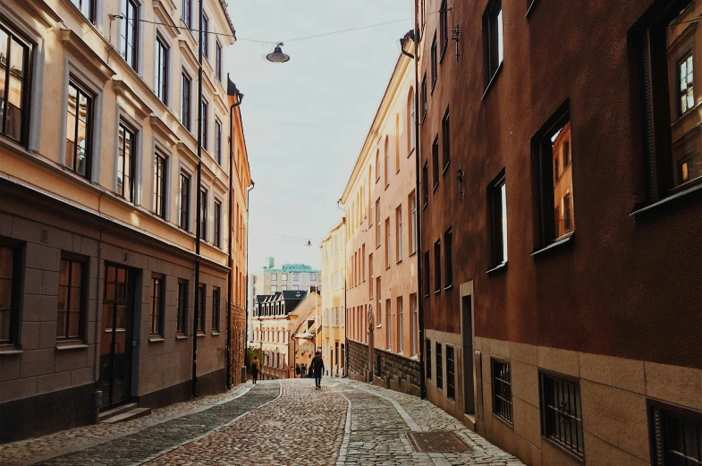 a couple of people walk down a narrow street