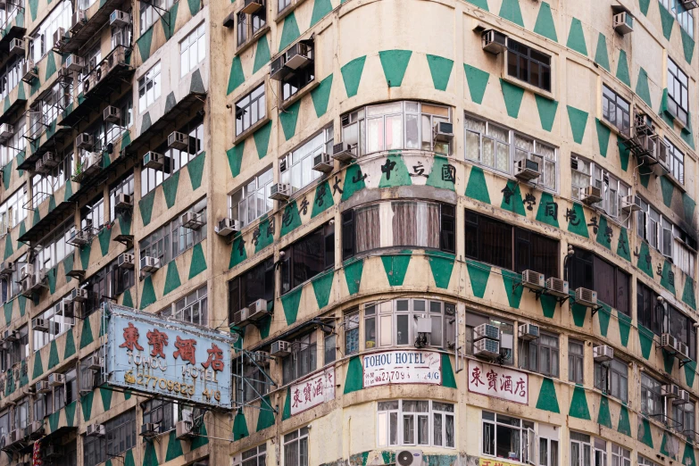 a high rise building that has green and white windows