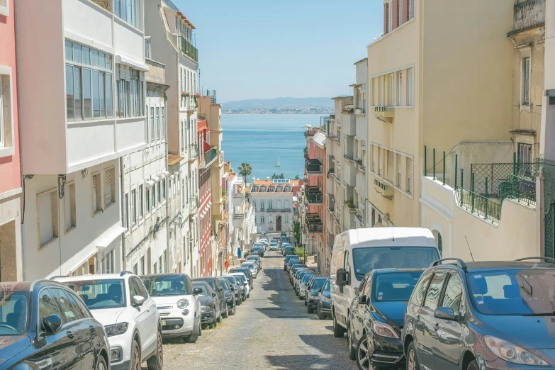 many cars parked near the city street next to the ocean