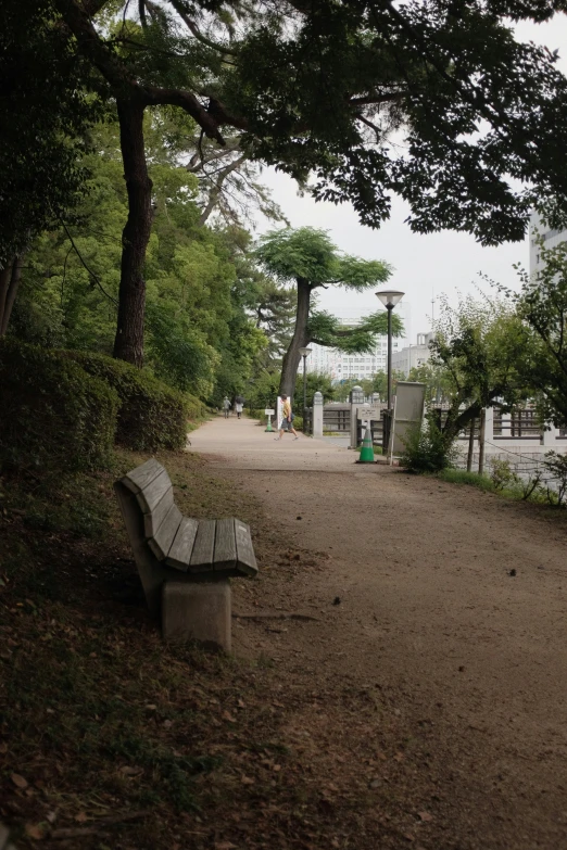 a stone bench in front of trees at a park