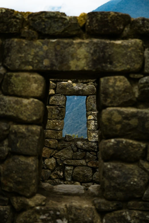 a view through a window to a hill and hills