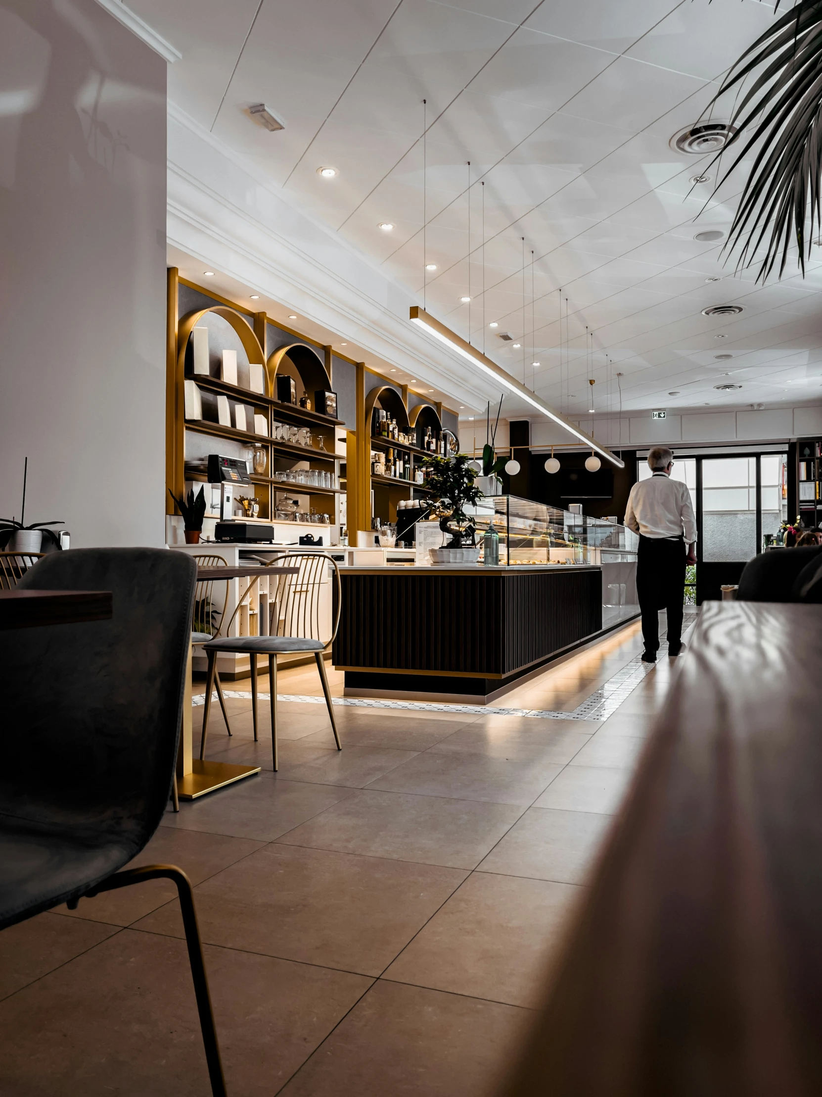 the interior of an upscale el with tables, chairs and wine racks