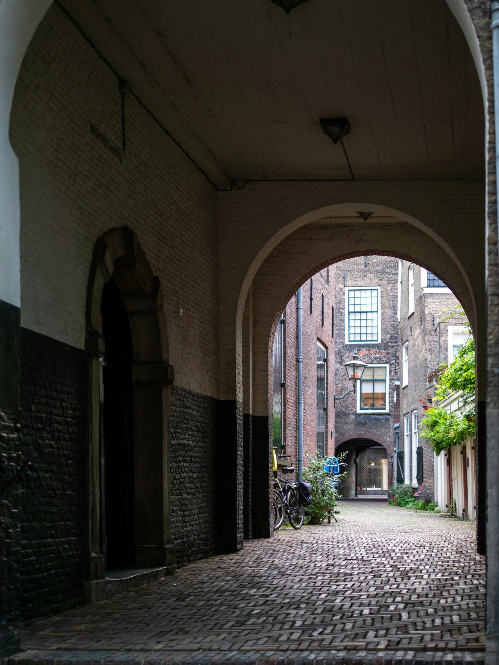 a brick walkway in an old building with a few arched doors