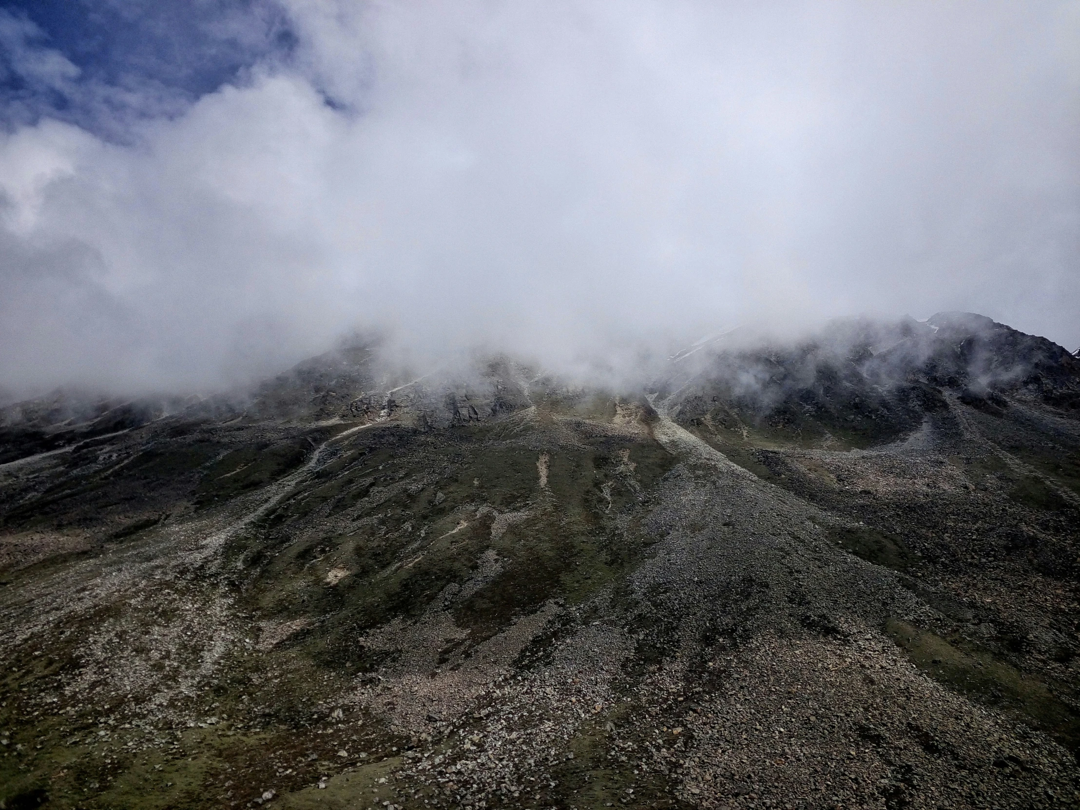 a view of a very high hill under the cloudy sky