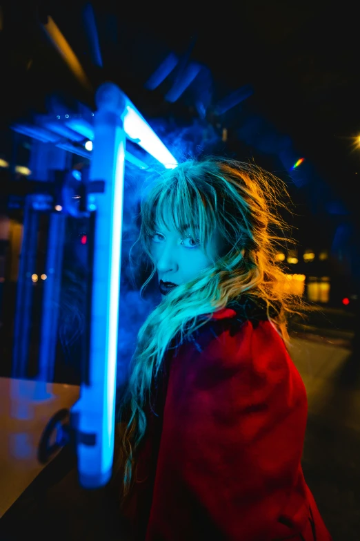 a woman with blonde hair standing under a blue light