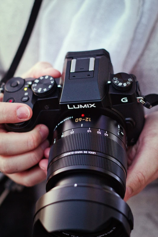 someone holding a camera up against a gray background