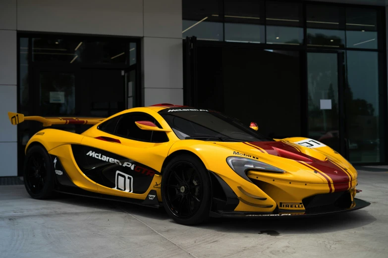 a yellow and red sport car sitting in front of a building